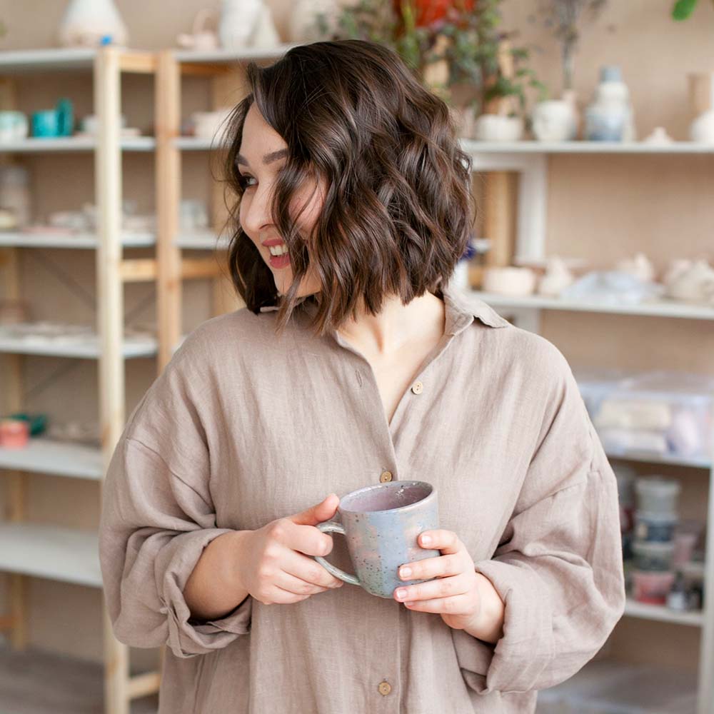 woman-smiling-and-holding-a-ceramic-cup-created-at-TW5R9GQ.jpg